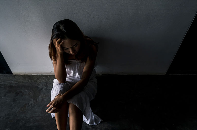 Young Woman Grieving on Concrete Floor