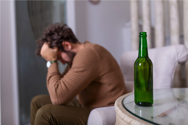 Man Frustrated with Beer Bottle on Table