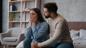 Woman cries as couple argues at home over substance use