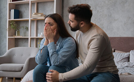 Woman cries as couple argues at home over substance use