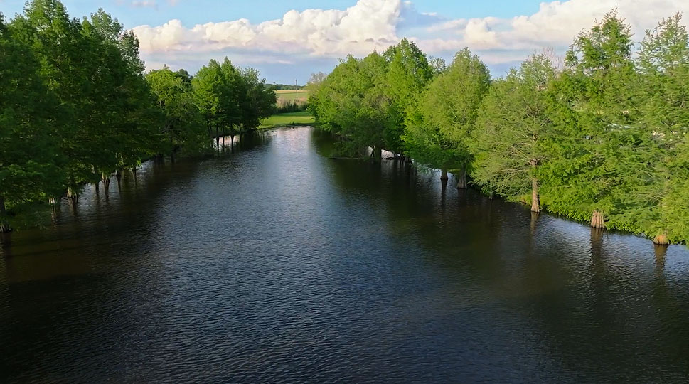Aerial view of the tree-lined lake at Burning Tree Ranch