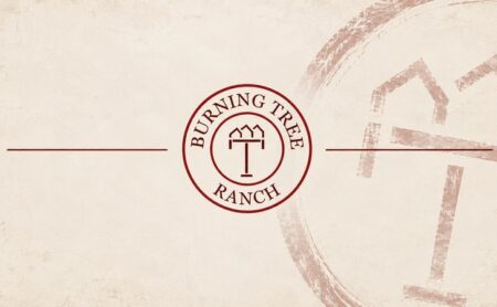 Burning Tree Ranch emblem centered between two burgundy rules on a cream background